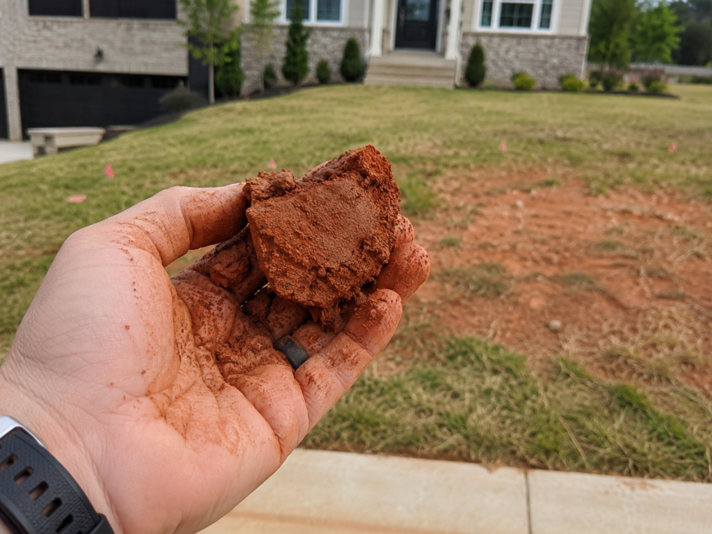 Inspecting Red Clay Soil