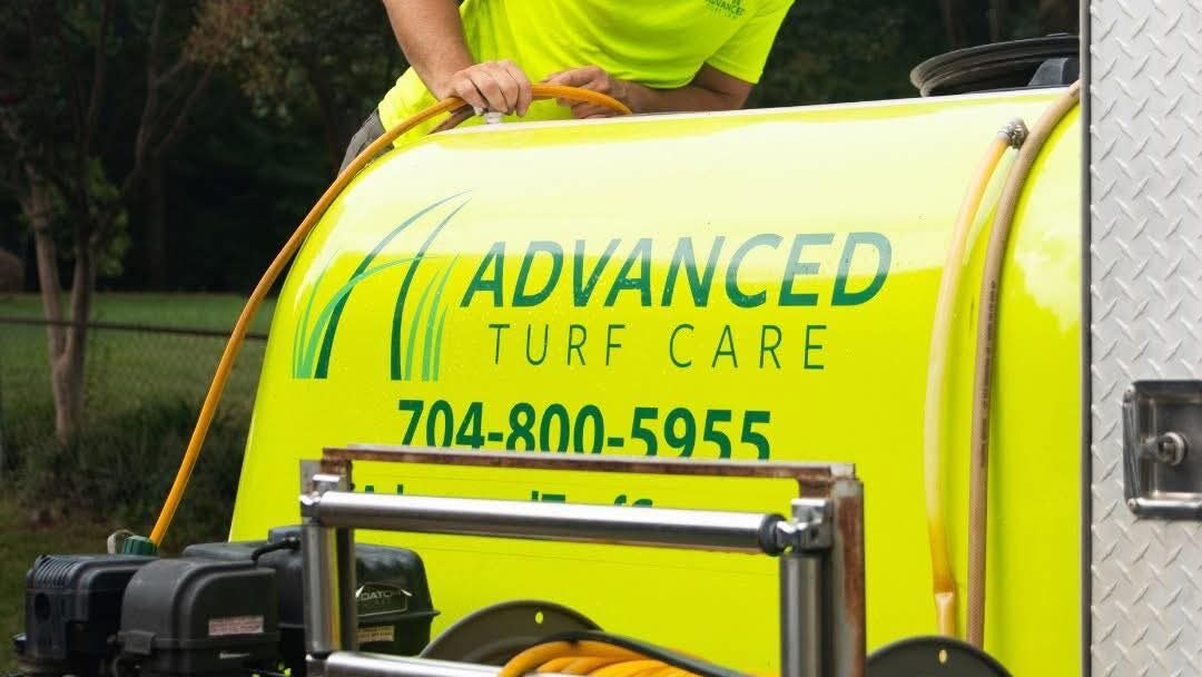 A team member of Advanced Turf Care checking fertilizer machine