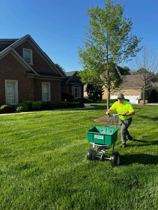 A team member of Advanced Turf Care working in a lawn