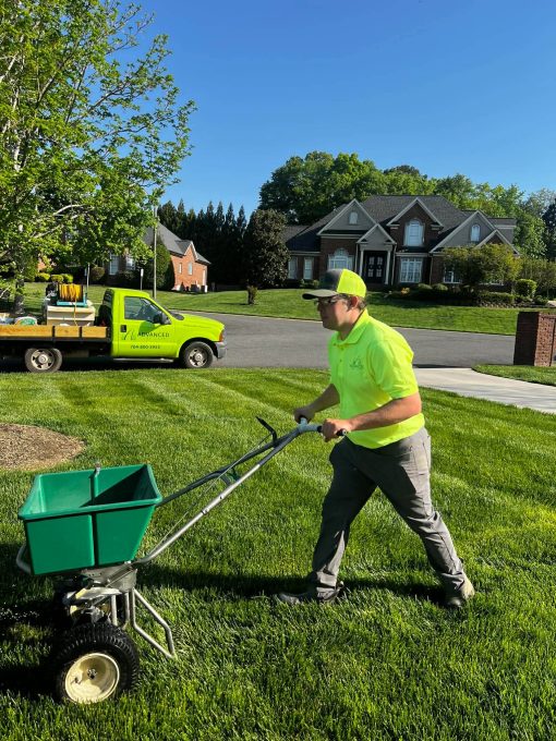 A team member of Advanced Turf Care applying fertilizer