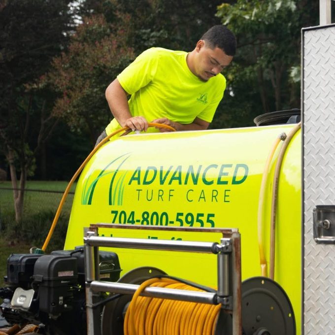 A team member of Advanced Turf Care checking fertilizer machine